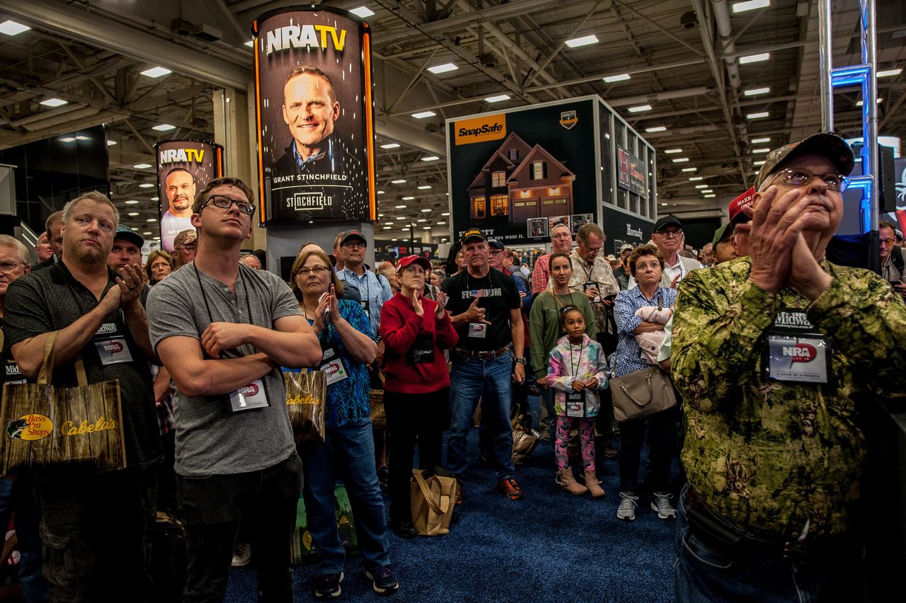 A crowd watches a screen showing a live feed of President Trump's speech at the NRA annual meeting on May 4.
