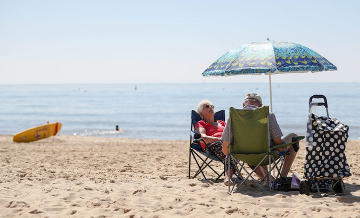 People enjoy the warm weather on Boscombe beach in Dorset.