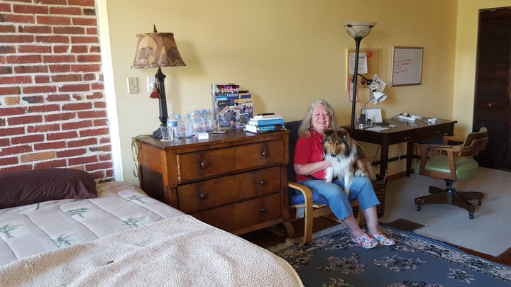 Baltimore resident Jeannette Belliveau, who rents a couple of rooms in her historic townhouse to short-term guests, sits with her dog, Copper, in one of the guest suites. States are having a hard time regulating the short-term rental industry.