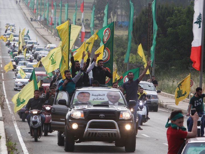 Supporters of Lebanon's Hezbollah and Amal Movement gesture as they ride in a car in Marjayoun, Lebanon May 7, 2018. 