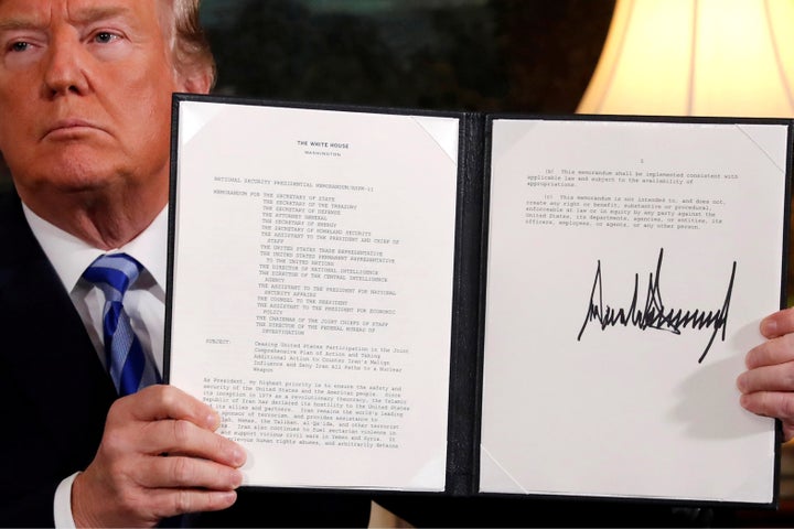Trump holds up a proclamation declaring his intention to withdraw from the JCPOA Iran nuclear agreement after signing it in t