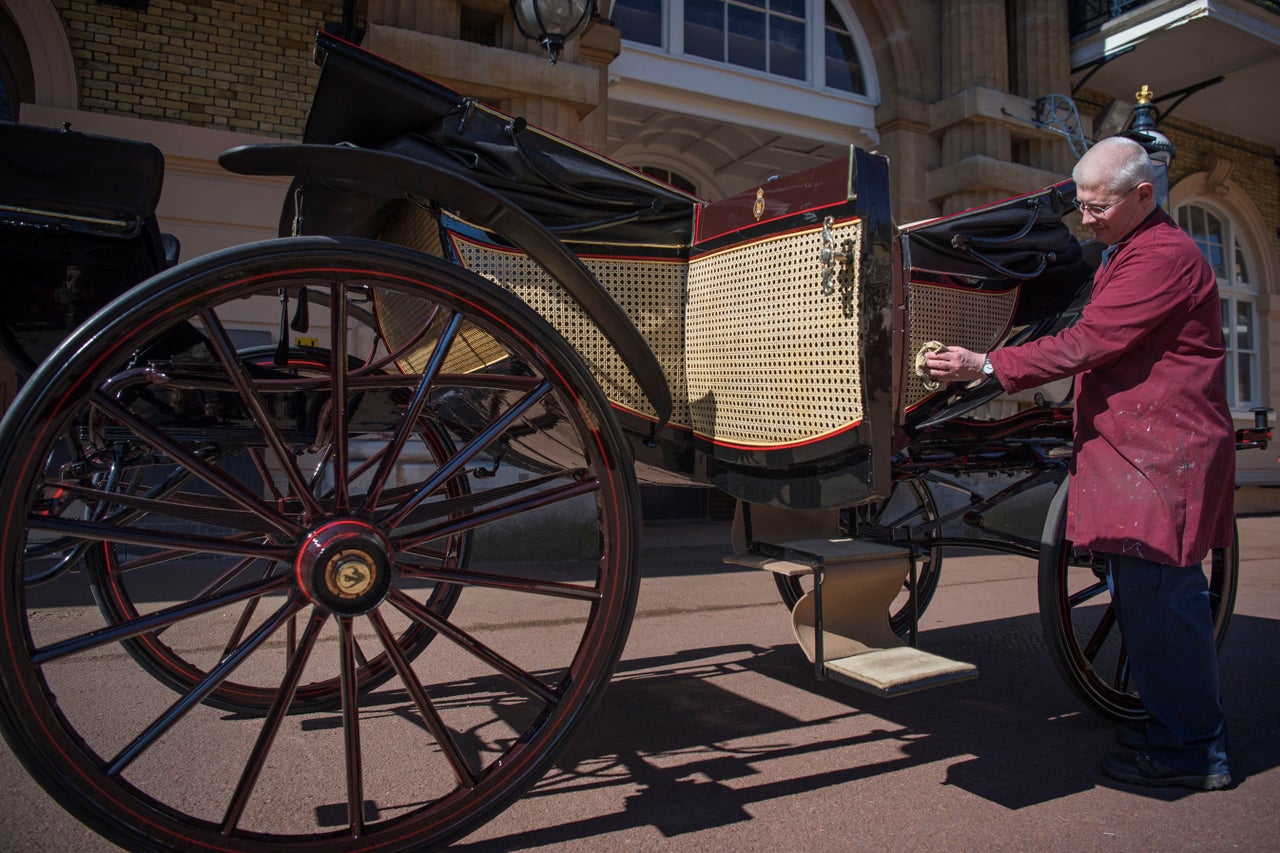 A senior carriage restorer polishes the Ascot Laundau which will be used at Harry and Meghan's wedding 