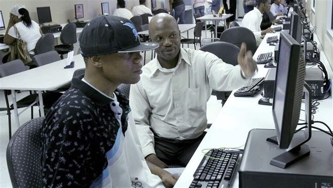 An employment office worker in Tallahassee, Florida, helps a young man look for jobs and send out applications. Policymakers are looking to Nevada as a potential model for success.