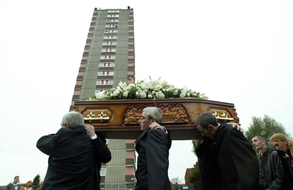 Family members of murdered Belfast mother Jean McConville, poignantly stop at the only remaining Divis Flats tower, the area from where the Irish Republican Army abducted her, before her funeral in west Belfast, Northern Ireland, 1 November 2003. 