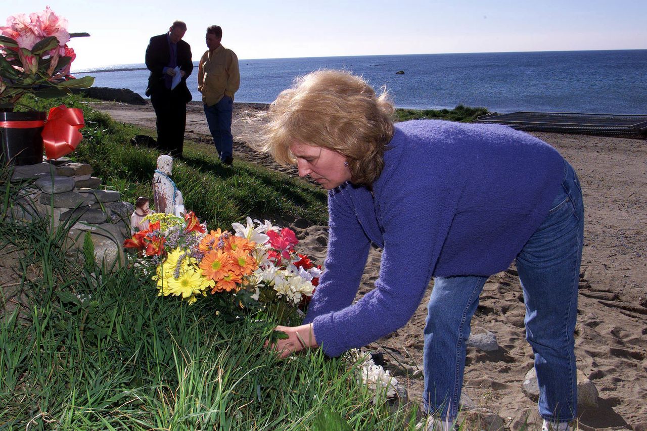 Helen McKendry lays flowers on Templetown beach in Co Louth, Irish Republic during a search for her mother's remains in the 90s.
