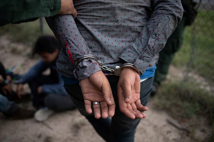 A Border Patrol agent apprehends someone caught illegally crossing the U.S. border near McAllen, Texas.