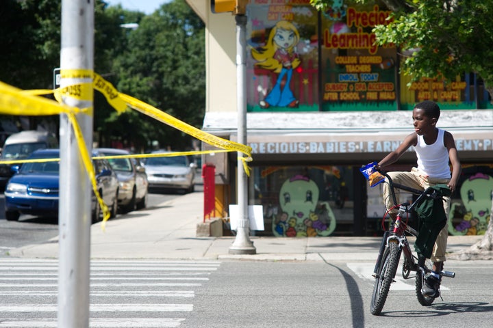 A boy circles on a bike near the site of a crime investigation after a shooting in North Philadelphia. Pennsylvania Gov. Tom
