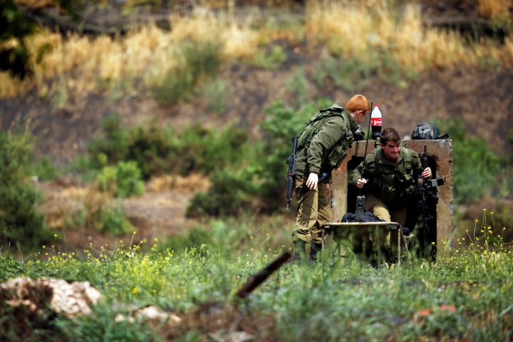 Israeli soldiers can be seen near the Israeli side of the border with Syria in the Israeli-occupied Golan Heights, Israel May