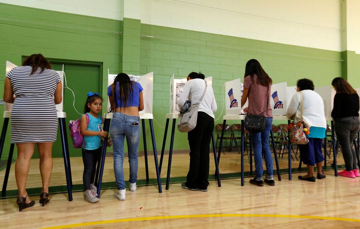 Brisa Silva stands next to her mother, Cinthia Lopez, as she votes at the Evergreen Recreation Center during the presidential election in the Boyle Heights area of Los Angeles on Nov. 8, 2016.
