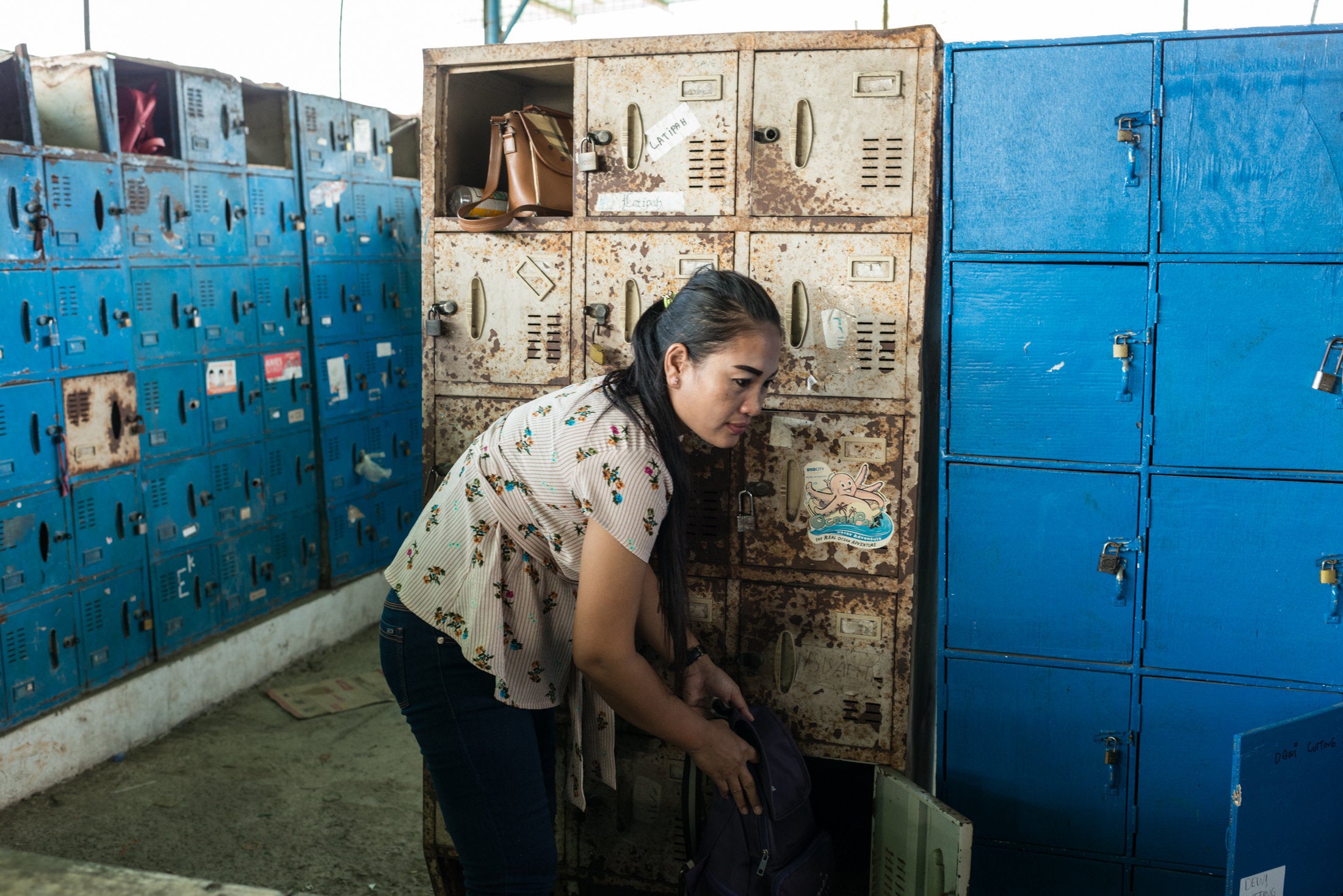 Istiyaroh, 35, an employee at Kaho Indah Citra Garment factory in North Jakarta, collects her bag from a locker when she fini