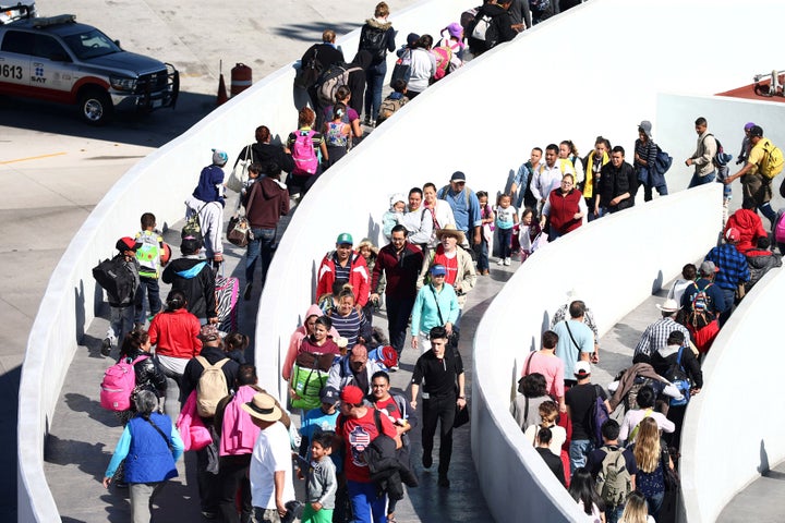 Members of a caravan of migrants, who are mostly from Central America, enter a United States border and customs facility, where they are expected to apply for asylum, in Tijuana, Mexico, on May 4. 