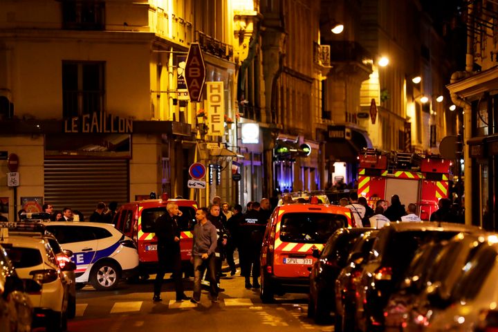 Policemen and emergency responders stand in a blocked street in Paris near the site of Saturday's knife attack.