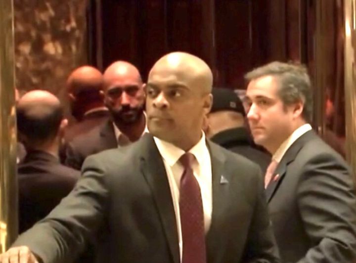 A photo apparently taken from a C-Span video appears to show Michael Cohen (right) about to enter a Trump Tower elevator with a man who looks like Qatari Ahmed al-Rumaihi (left), looking over the shoulder of the lobby guard.