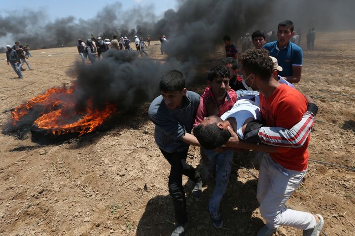 A wounded Palestinian demonstrator is evacuated during a protest against U.S. embassy move to Jerusalem and ahead of the 70th