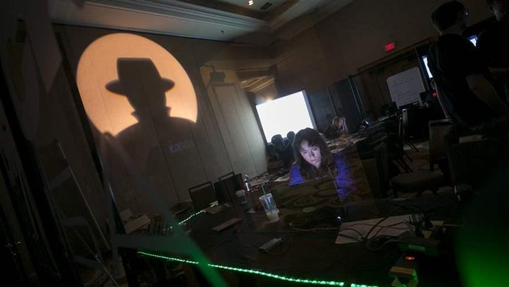 A tech associate works at the Black Hat information security conference in Las Vegas last year. Some states are turning to white-hat hackers to uncover vulnerabilities in their computer networks. 