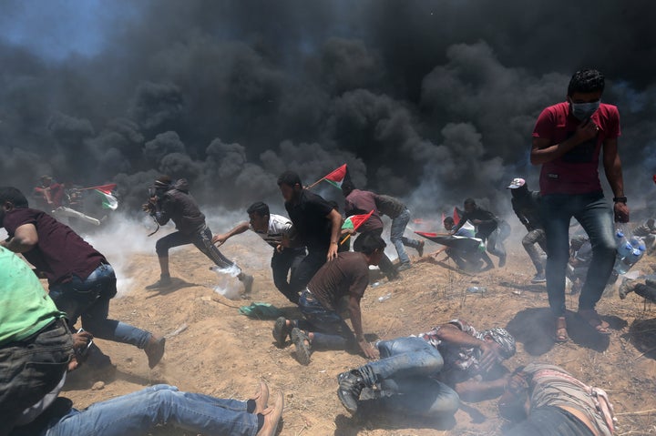 Palestinian demonstrators run for cover from Israeli fire and tear gas during a protest against the U.S. embassy's move to Jerusalem.