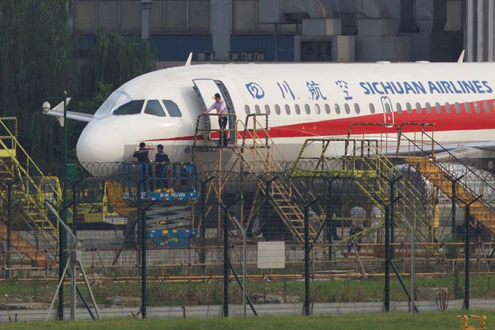 Workers inspect a Sichuan Airlines aircraft that made an emergency landing after a windshield on the cockpit broke off, at an airport in Chengdu, Sichuan province, China on May 14, 2018.