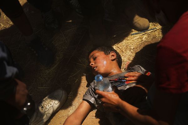 A child overcome by tear gas receives medical help. 