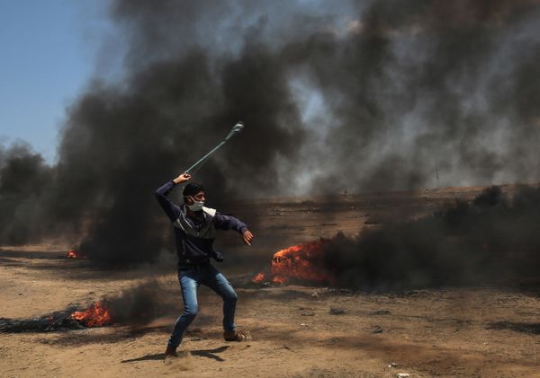 A Palestinian man uses a slingshot during clashes with Israeli forces. 