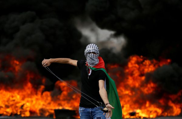 A Palestinian demonstrator holds a sling during a protest marking the 70th anniversary of Nakba, near the Jewish settlement o