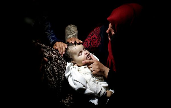  A relative mourns as she carries the body of eight-month-old Palestinian infant Laila al-Ghandour, who died after inhal