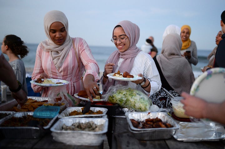 Muslim American friends take part in the last Iftar of Ramadan, ahead of Eid al-Fitr celebrations, on a beach in Long Branch,