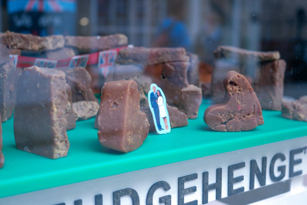 A mini Meghan and Harry stand among a fudge Stonehenge display on Salisbury high street.
