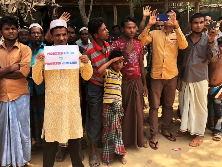 Rohingya refugees line the streets as United Nations Security Council vehicles pass outside Kutupalong Refugee Camp