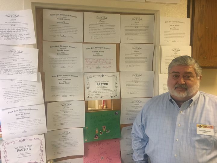 The Rev. David Meredith stands next to a door with supportive messages from his congregation at Clifton United Methodist Church in Cincinnati.