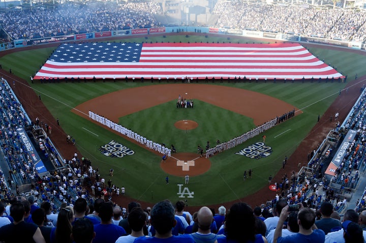 A man salutes during the national anthem before a baseball game