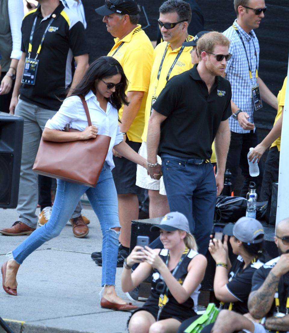 Harry and Megham holding hands at the Invictus Games Toronto in 2017 