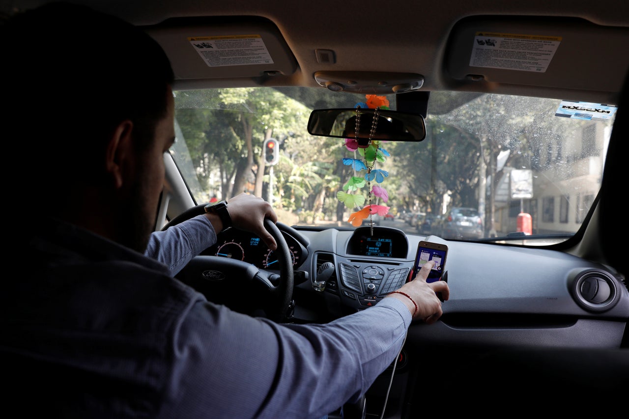 An Uber driver checks the Uber app inside his car in Mexico City, Mexico. 