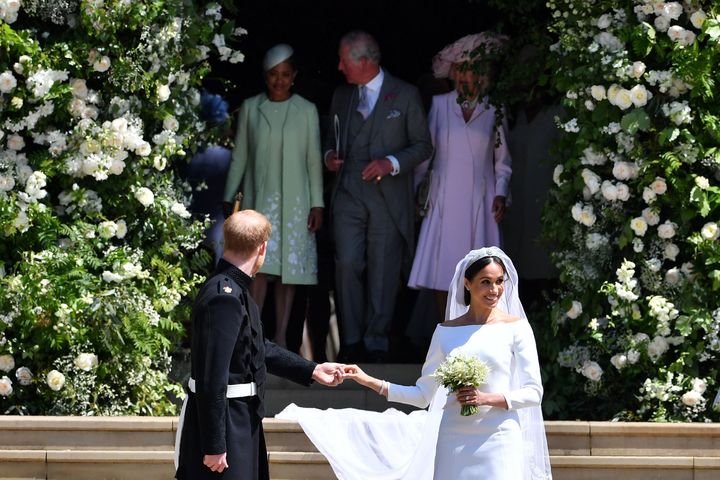Harry turns around to find his father Charles taking good care of Meghan's mom. 