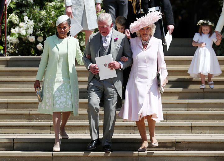 Charles walks arm-in-arm down the steps outside the chapel with both Ragland (left) and Camilla (right). 