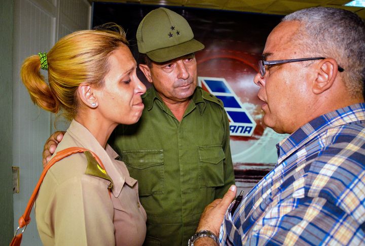 The first secretary of Communist Party in the Cuban city of Holguin, Luis Antonio Torres Iribar (R), speaks with a relative of one of the victims of the plane crash.
