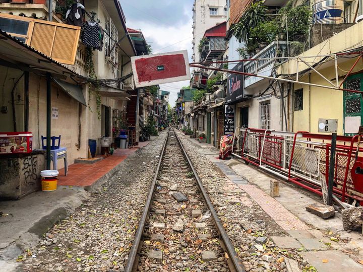 In the crowded streets of smoggy Hanoi, a train passes very, very close by people's homes.