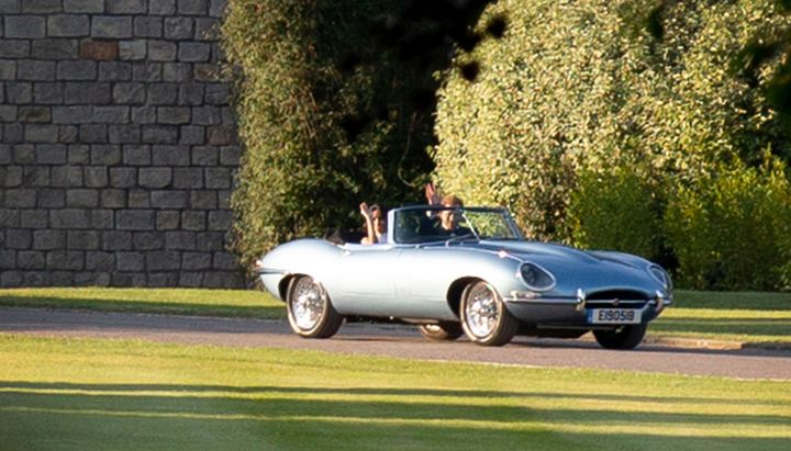 Prince Harry, Duke of Sussex, and Meghan, Duchess of Sussex, are seen leaving Windsor Castle following their wedding in the E-type Jaguar.
