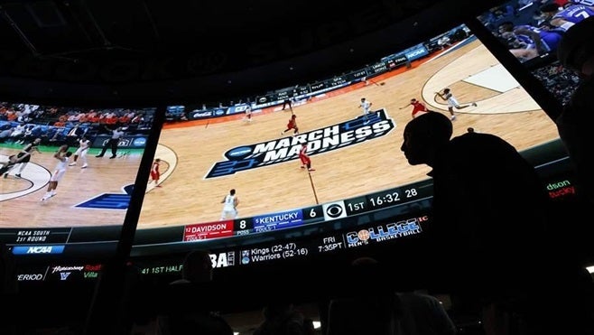 People wait in line to bet on the NCAA college basketball tournament at the Westgate Superbook sports book in Las Vegas. The
