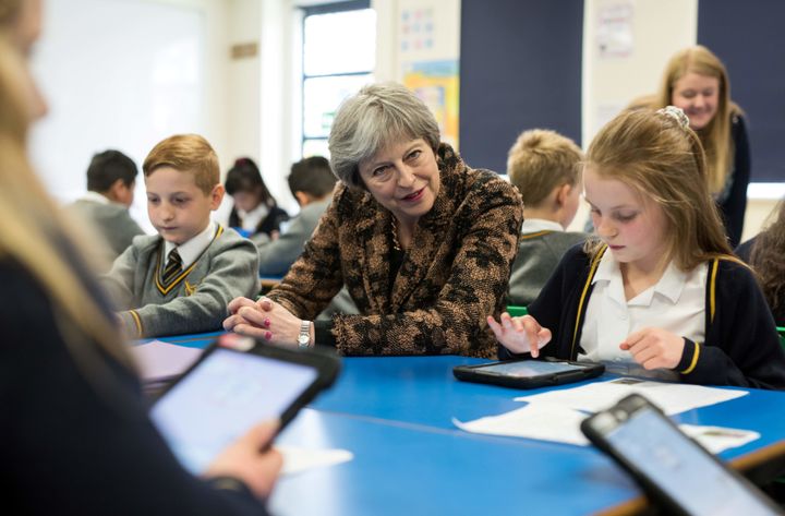 Britain's Prime Minister Theresa May (C) meets with pupils as she visits Brooklands Primary School in Sale, near Manchester