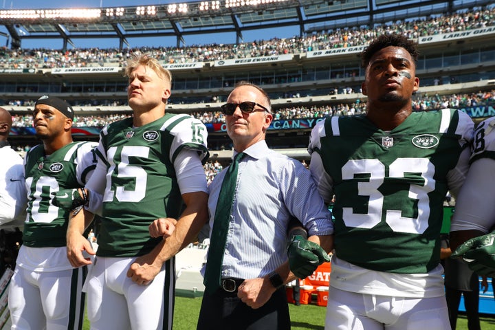 Christopher Johnson locks arms with players during the national anthem before a game in September 2017.