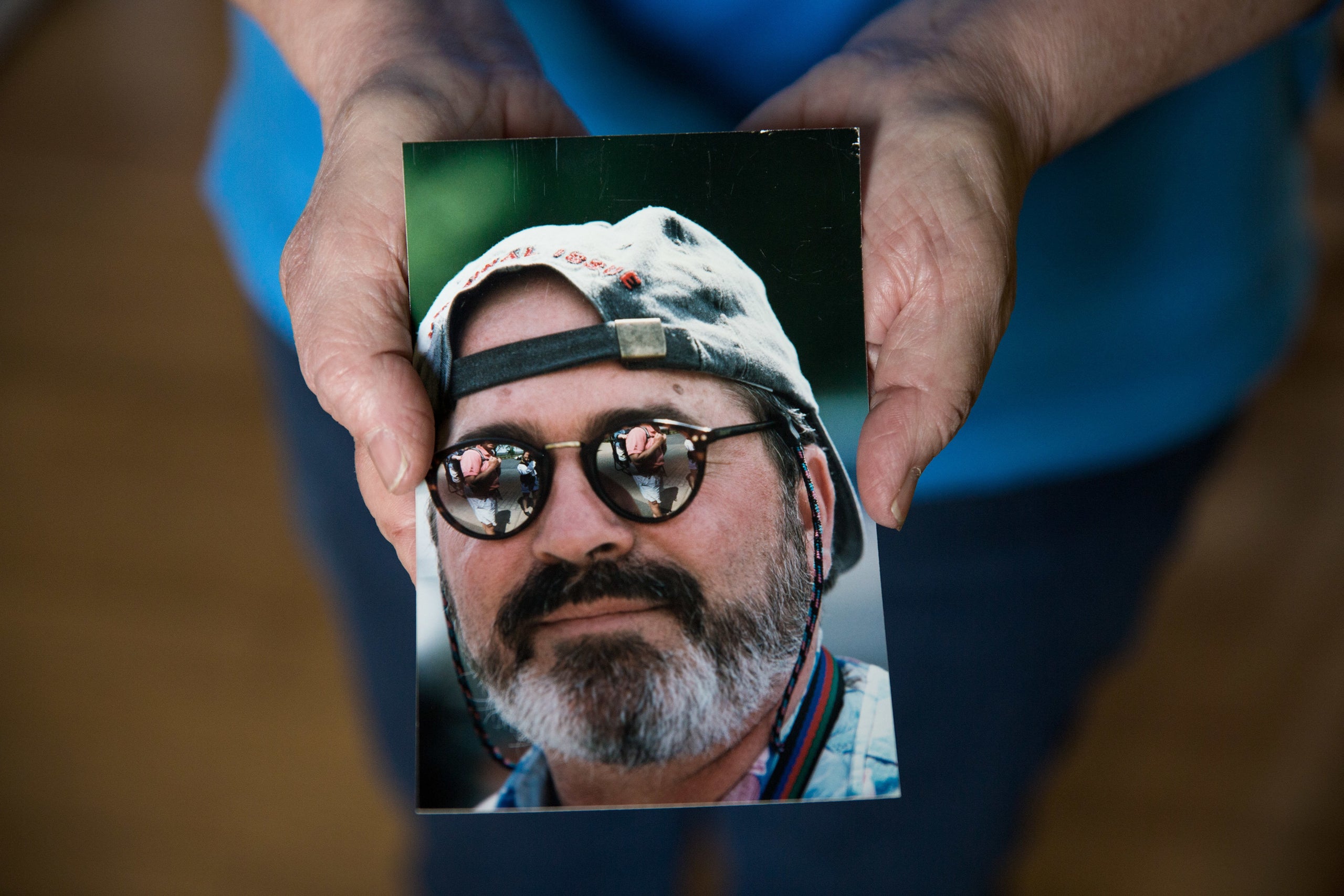 Kate Naylor holds a photo of her late husband, Pete Naylor. 