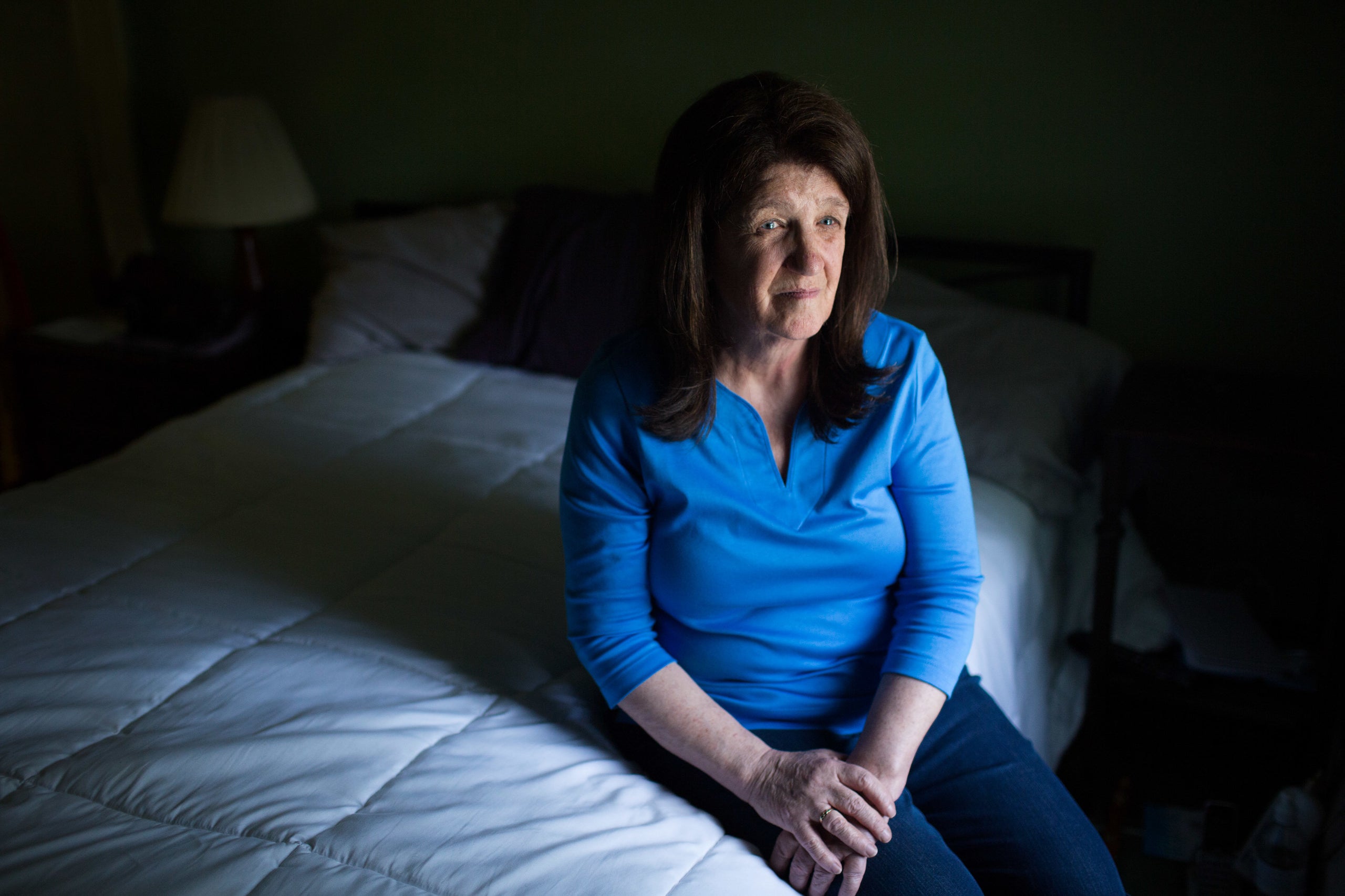 Kate Naylor poses for a portrait in the bedroom that she shared with her husband, Pete Naylor.