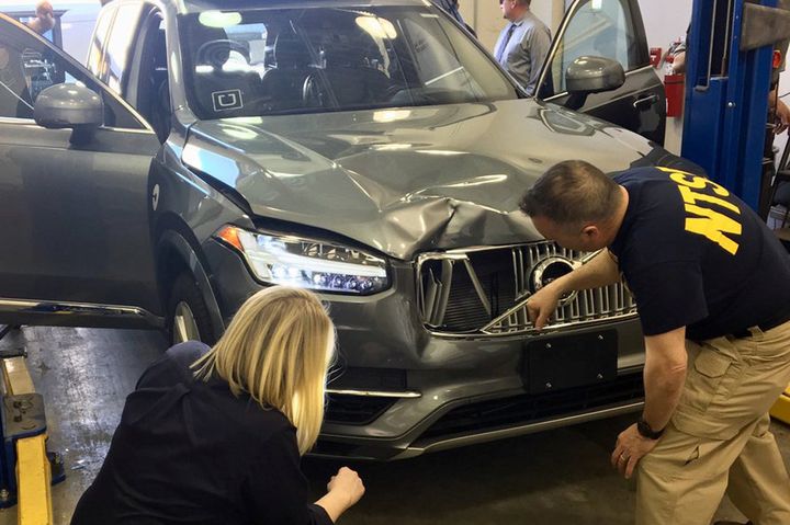 National Transportation Safety Board investigators examine the self-driving Uber vehicle involved in the fatal accident.
