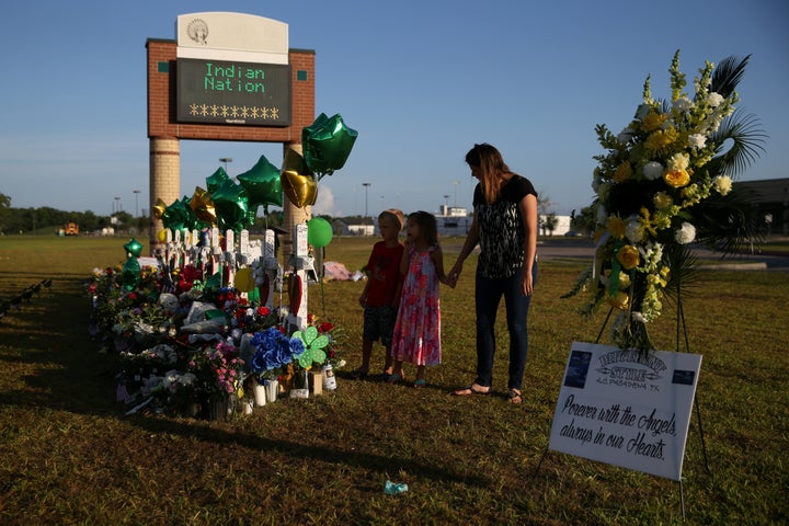A woman and her children pay respects at a makeshift memorial at Santa Fe High School in Santa Fe, Texas, May 23, 2018. Survi