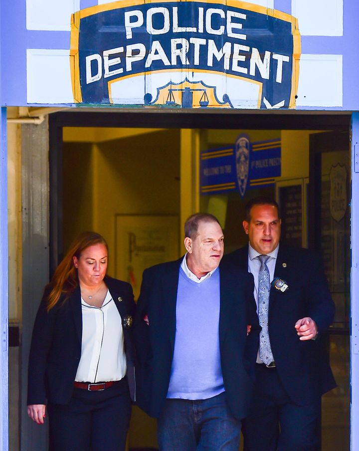 Harvey Weinstein is escorted out of the New York Police Department's First Precinct in handcuffs after turning himself in on Friday