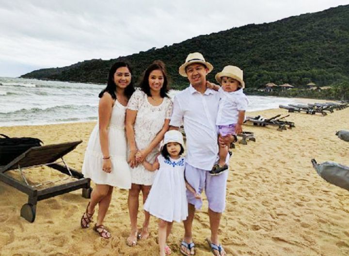 Mia Lobo poses for a family photo at the beach.