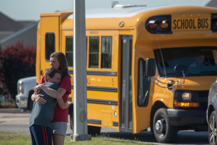 A student and adult embrace outside Noblesville West Middle School after a shooting at the Indiana school on Friday.