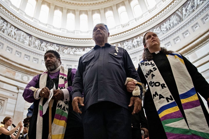 The Rev. William Barber, the Rev. Jesse Jackson and the rev. Liz Theoharis lead protesters through the U.S. Capitol Rotunda b
