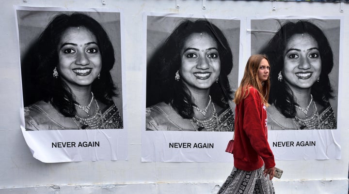 A young woman walks past art work featuring Savita Halappanavar 