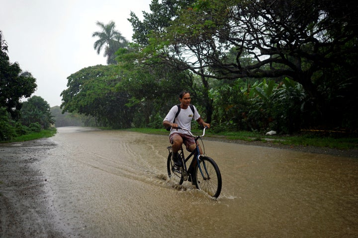 A man rides a bicycle down a flooded road in Bahia Honda, Cuba, as Subtropical Storm Alberto passes by the Caribbean island's west coast on Saturday.